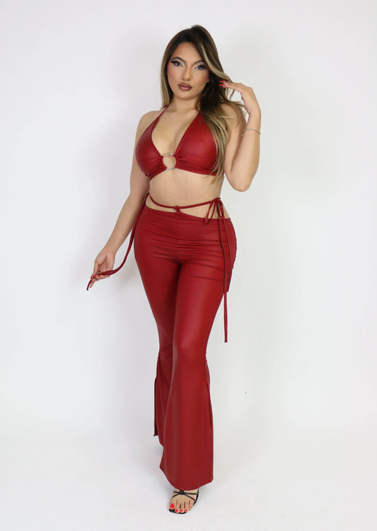 blonde latina wearing a red faux leather matching two piece set triangle crop top with ring detail and bell bottom faux leather pants